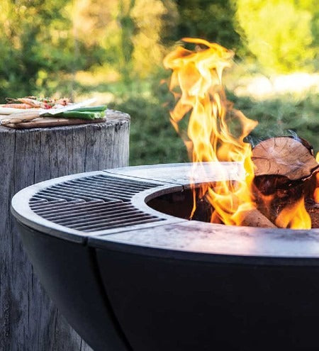 Castworks Hergóm Meteor low base outdoor fire pit complete set with fire bowl, stand, and accessories for outdoor fireplaces.