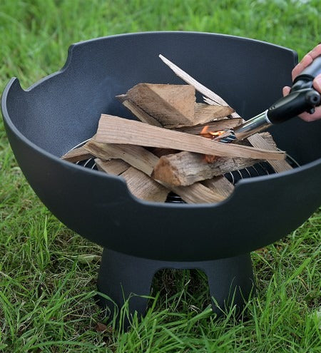 Castworks Hergóm Meteor low base outdoor fire pit with open-top design and sturdy metal construction.