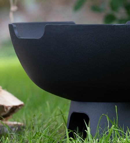 Castworks Hergóm Meteor low base outdoor fire pit with a round metal design and open top, ideal for outdoor heating and gatherings.