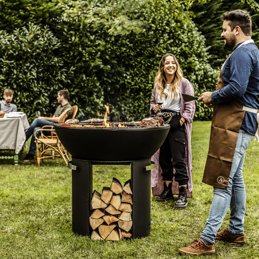 Castworks Hergóm Zenith High Base Fire Pit complete outdoor fireplace set with metal fire bowl and fire tools.