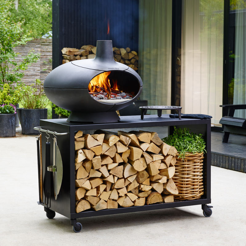 Morsø Forno outdoor oven garden set with cooking accessories and stone countertop for outdoor cooking and dining.