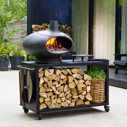 Morsø Forno outdoor oven garden set with cooking accessories and stone countertop for outdoor cooking and dining.