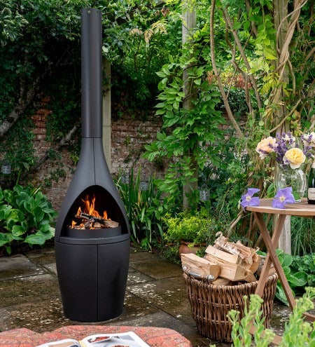 Morsø Kamino outdoor oven and fireplace, black metal outdoor fire feature with a modern design and chimney for outdoor cooking.